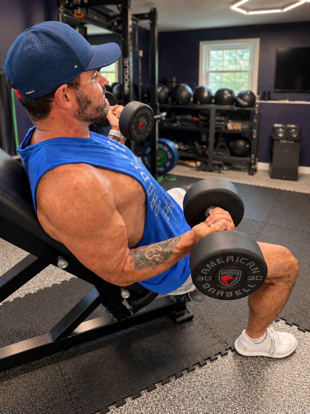 Colin performing seated dumbbell curls in a studio setting